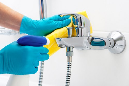 Cleaner working on a sofa in an Islington flat with narrow access
